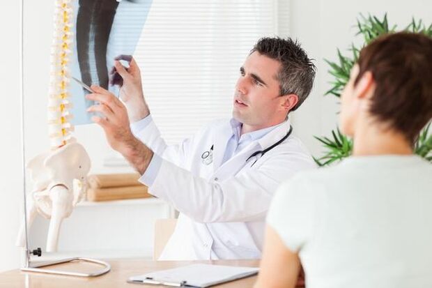 Ο γιατρός δείχνει τη βλάβη στη σπονδυλική στήλη που προκαλείται από την αυχενική οστεοχόνδρωση